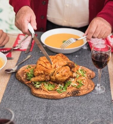 old man cutting baked chicken festive table 23 2147973677 Bin Recipes