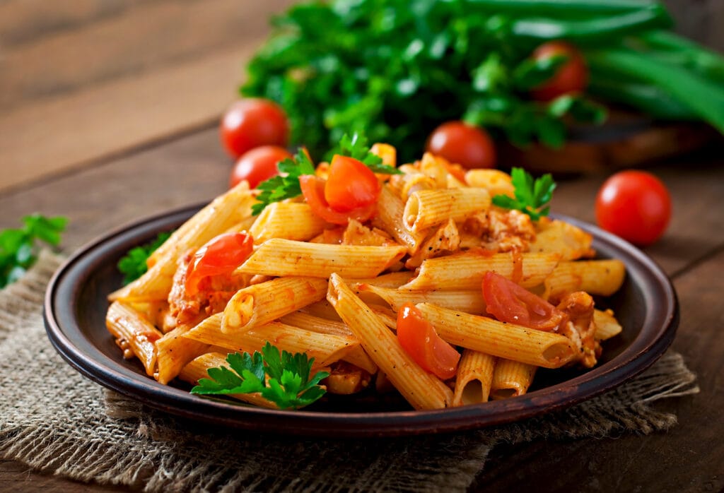 penne pasta tomato sauce with chicken tomatoes wooden table Bin Recipes