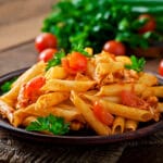 penne pasta tomato sauce with chicken tomatoes wooden table Bin Recipes