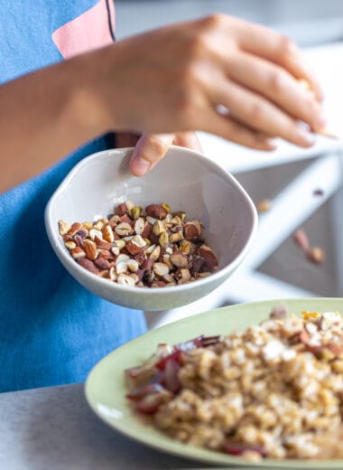 woman prepares oatmeal with fruits closeup Bin Recipes